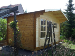 Zahradní domek má sedlovou střechu v přední části prodlouženou o 70 cm